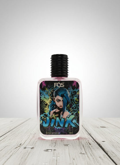 Perfume bottle with colorful label featuring a character and the word 'Jinx' on a wooden surface.